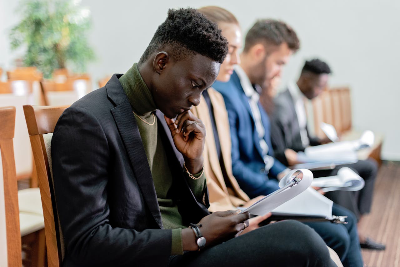 Home Four diverse professionals in a focused business meeting, reviewing documents in an office setting.